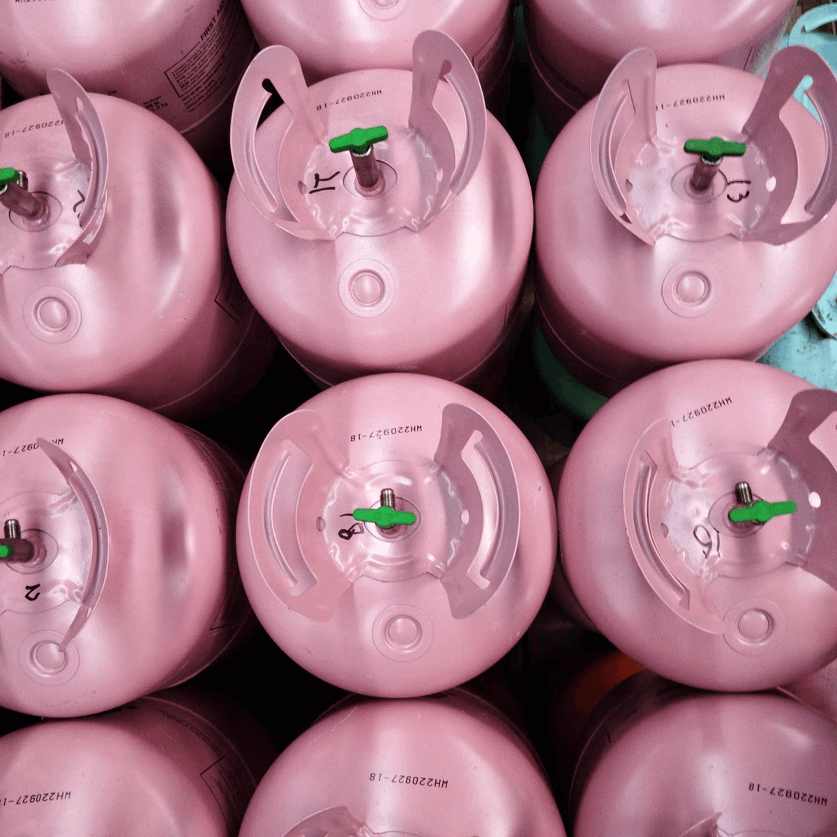 Rows of pink disposable cylinders in a warehouse from above