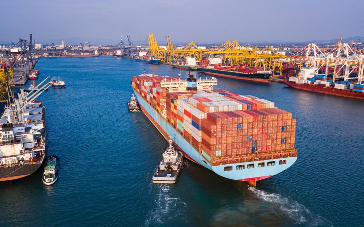 A ship full of shipping containers entering a harbour